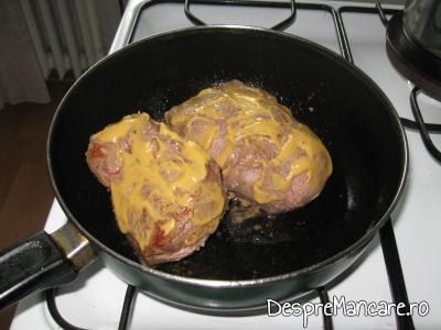 Bucati de spata unse cu mustar pentru preparare spata de porc cu legume si costita, la cuptor.