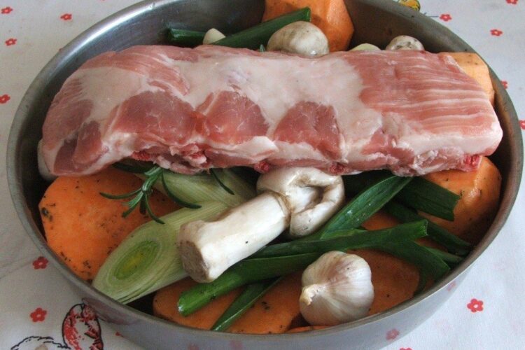 Ingredientele pentru coasta de porc cu legume, dovleac si ciuperci, la cuptor asezate in tava de copt.