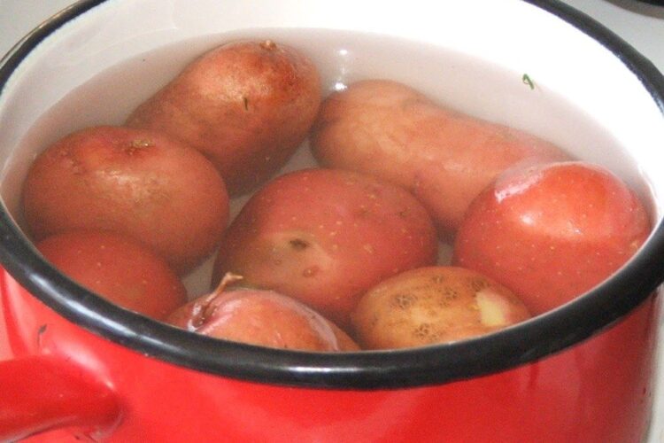 Fierbere cartofi in coaja pentru pulpa de miel impanata cu ansoa, cu garnitura de galbiori.