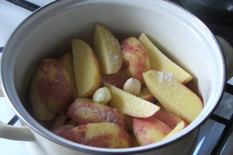 Cartofi noi, rosii, pusi la fiert in apa rece cu sare grunjoasa si 2 catei de usturoi.