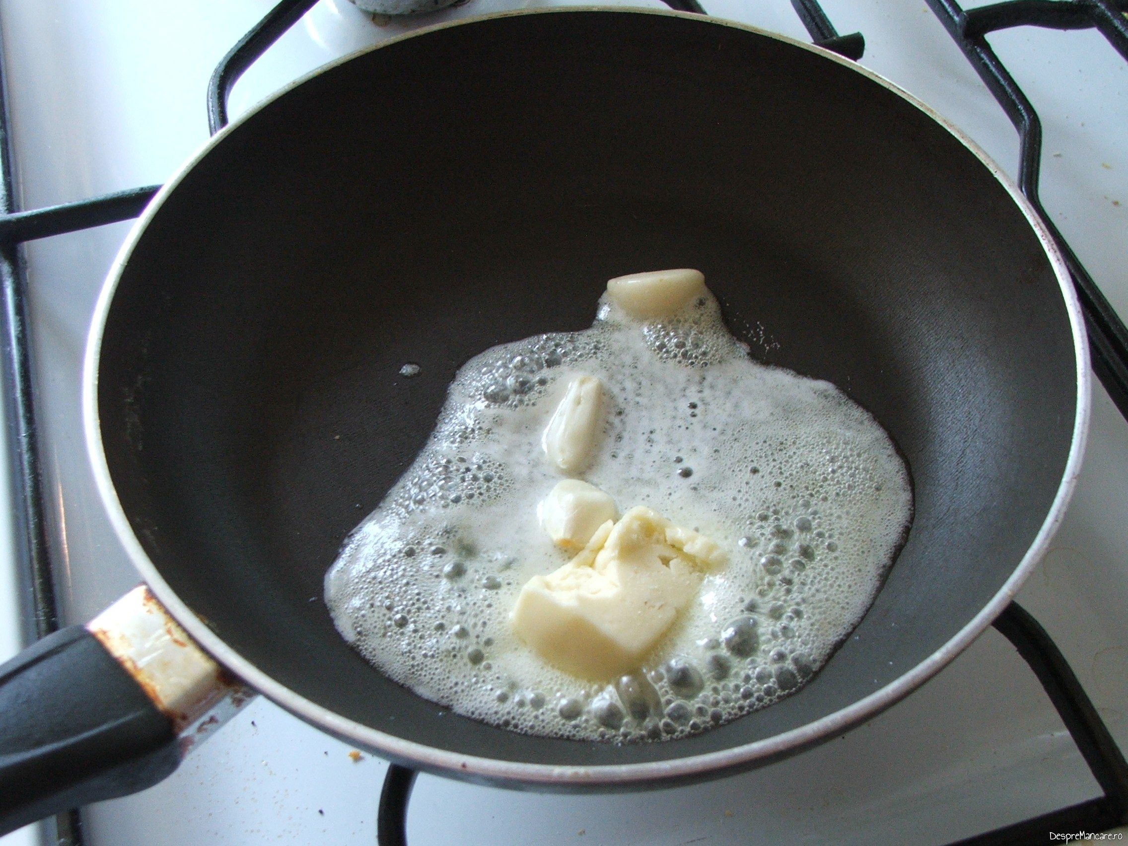 Amestec de ulei de masline si unt proaspat, cu catei de usturoi, pregatit pentru ochiuri cu cascaval afumat si paine prajita.