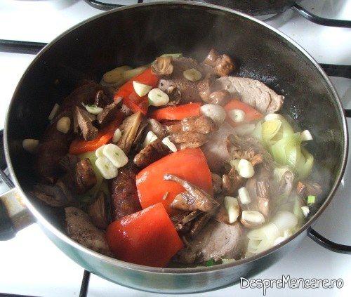 Usturoiul feliat subtire se adauga peste carnea si legumele gata pregatite pentru muschiulet si carnat de porc cu legume, la tigaie, in sos de smantana.