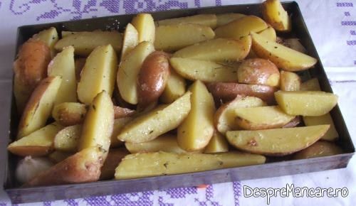 Cartofi fierti pe jumatate, asezonati cu sare si piper, pregatiti pentru a fi pusi la cuptor pentru muschi de porc cu ciuperci si cartofi, la tava.