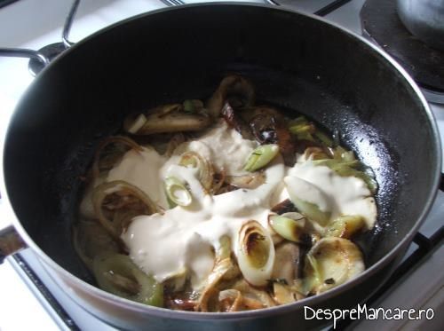 Adaugare smantana peste feliile de ciuperci si de praz, calite, pentru somon la cuptor cu sos de praz si smantana. 