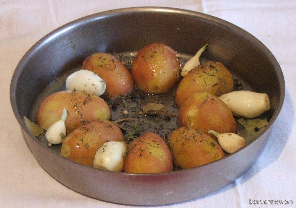 Asezare cartofi fierti in tava de copt, cu condimente, pentru spata si carnati proaspeti de porc, la cuptor.