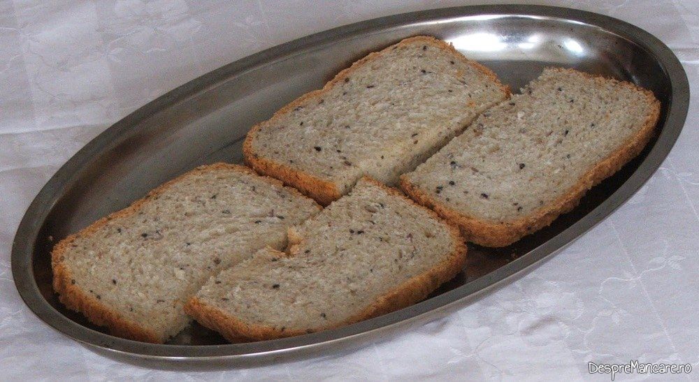 Felii de paine neagra, cu seminte puse in tava pentru prajire.