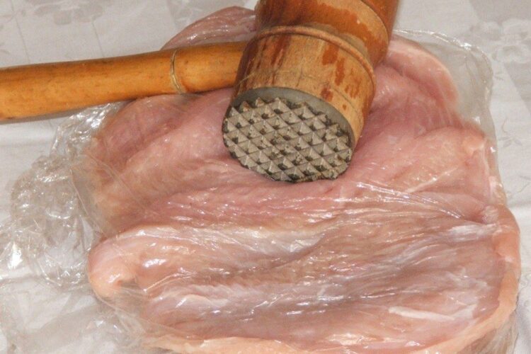 Marire suprafata la bucata de piept de curcan prin batere cu ciocanul de carne.