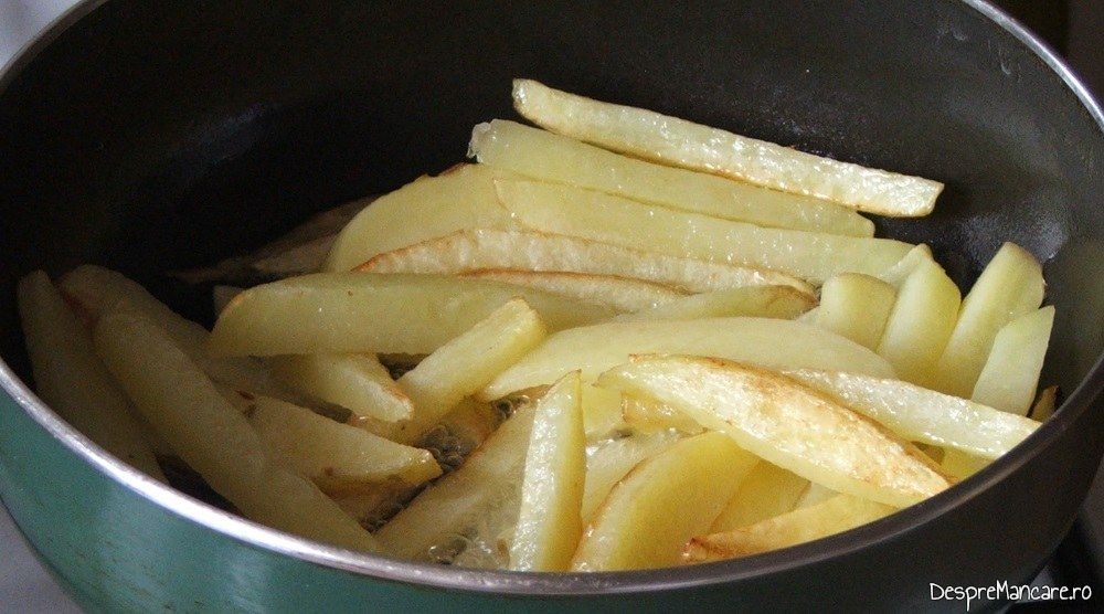 Prajire cartofi pai in grasimea de rata formata in urma prajirii pulpelor de rata.