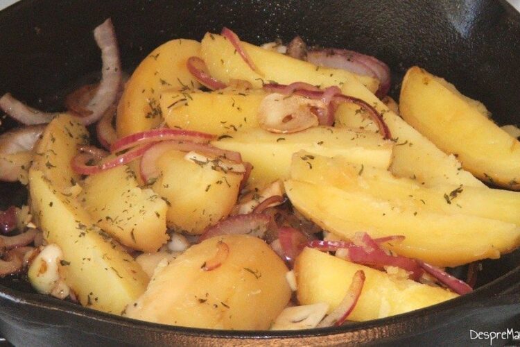 Prajire cartofi fierti si taiati in bucati mari, rondele de ceapa si felii de usturoi in untura de rata.
