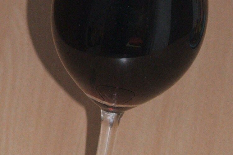 Vin negru servit la medalion din picior de vitel inabusit in vin.