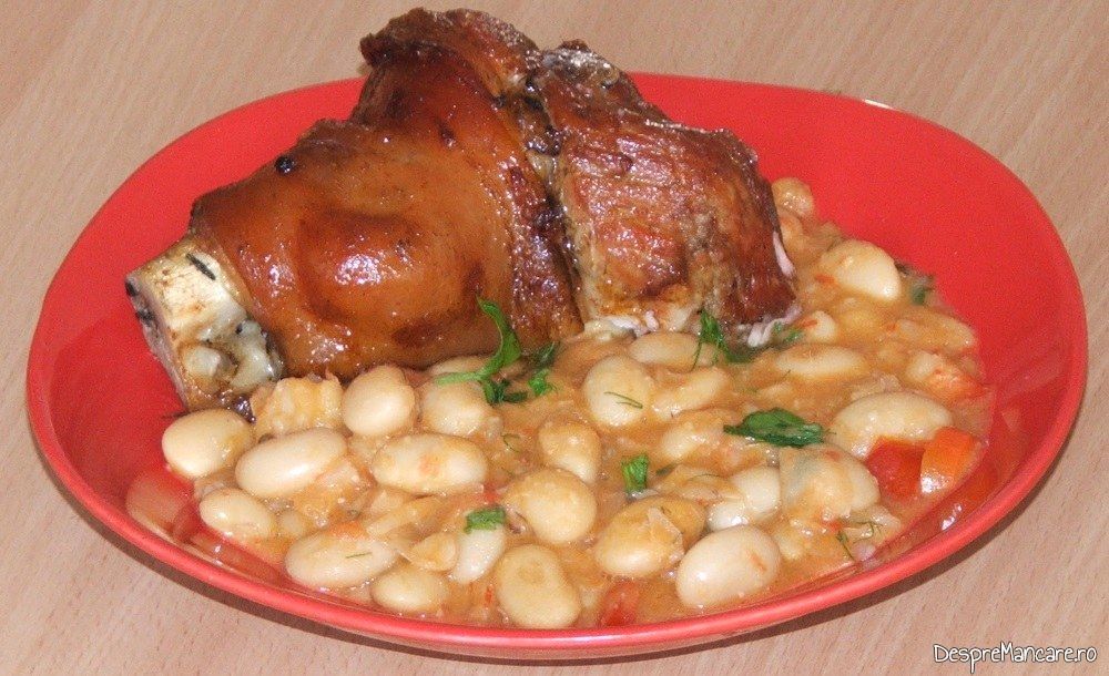 Ciolan proaspat de porc inabusit in bere si copt in cuptor, cu fasole boabe - preparatul este gata servit.