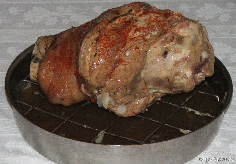 Ciolan proaspat de porc inabusit in vin pus in tava de copt pentru coacere in cuptorul aragazului, la foc potrivit.